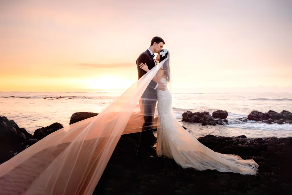 Couple kissing on lava rock after Big Island Wedding