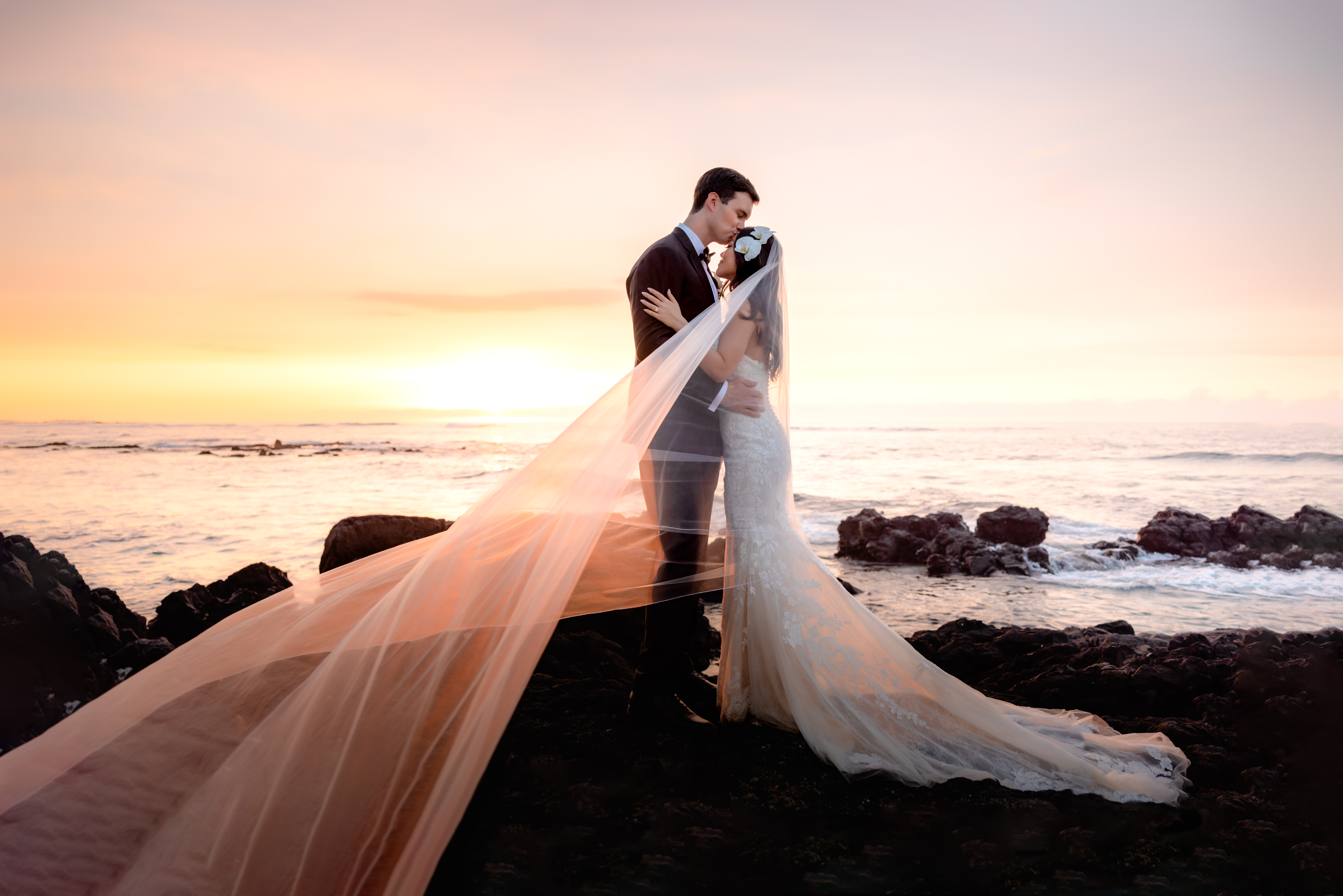 Couple kissing on lava rock after Big Island Wedding