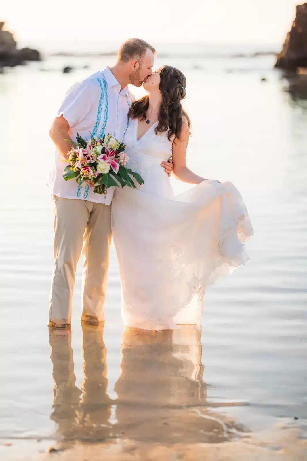 Couple dipping their toes in the ocean after their Big Island Hawaii elopement