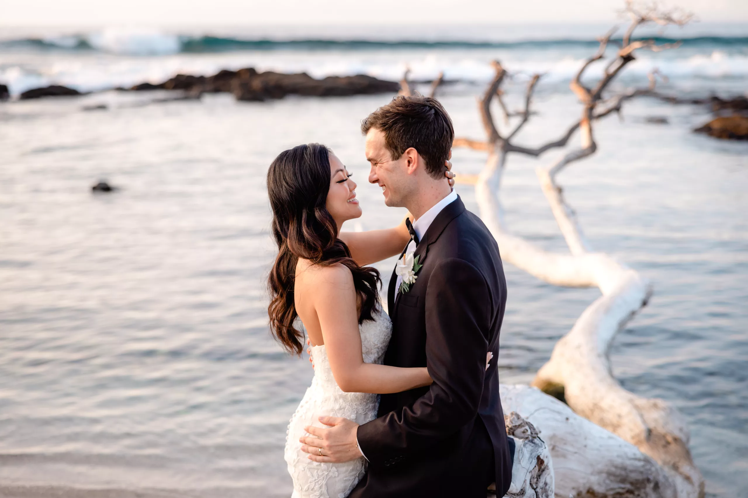 Couple on driftwood after Big Island Wedding at Fairmont Orchid