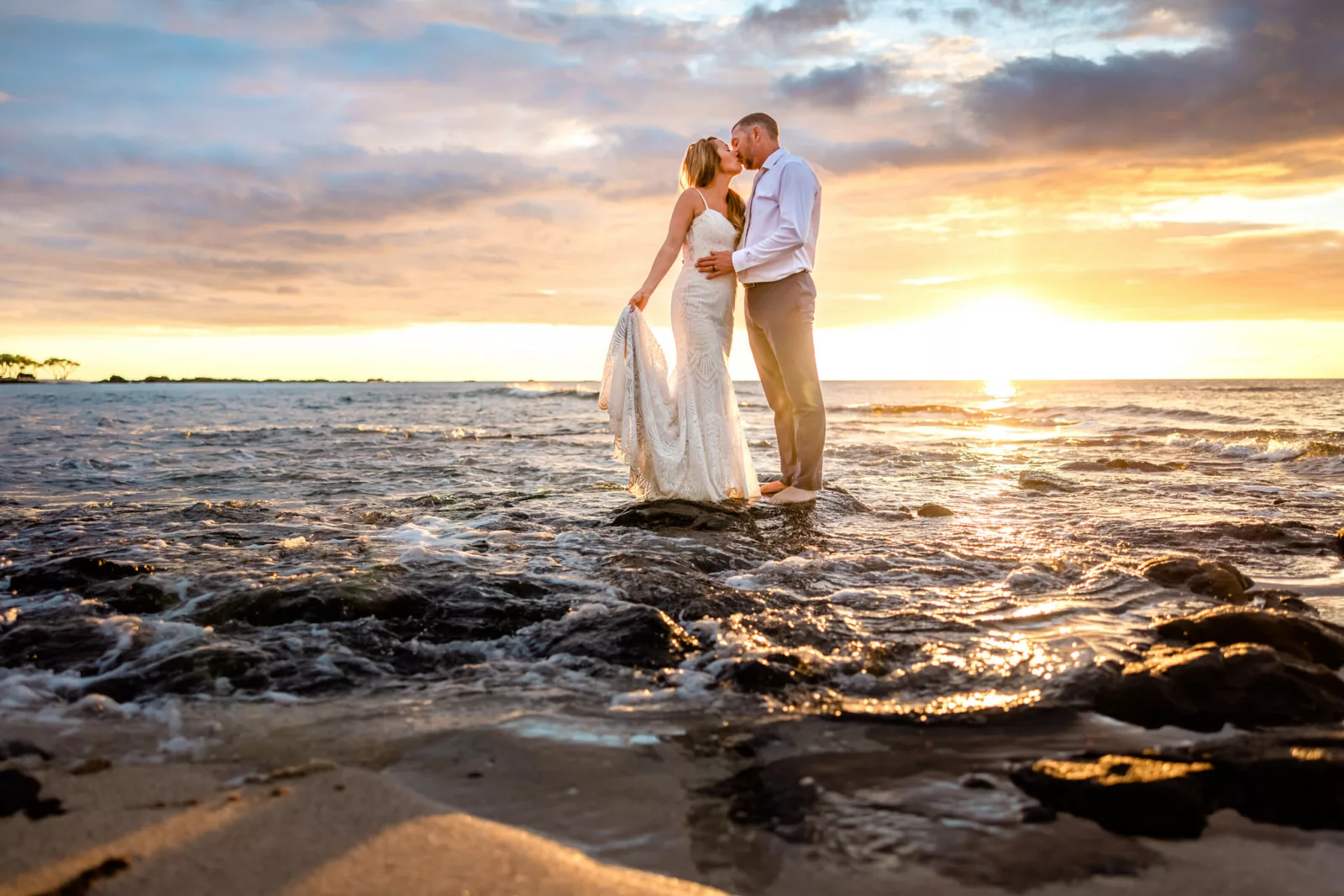 Couple splashing in the water after their  Big Island destination wedding