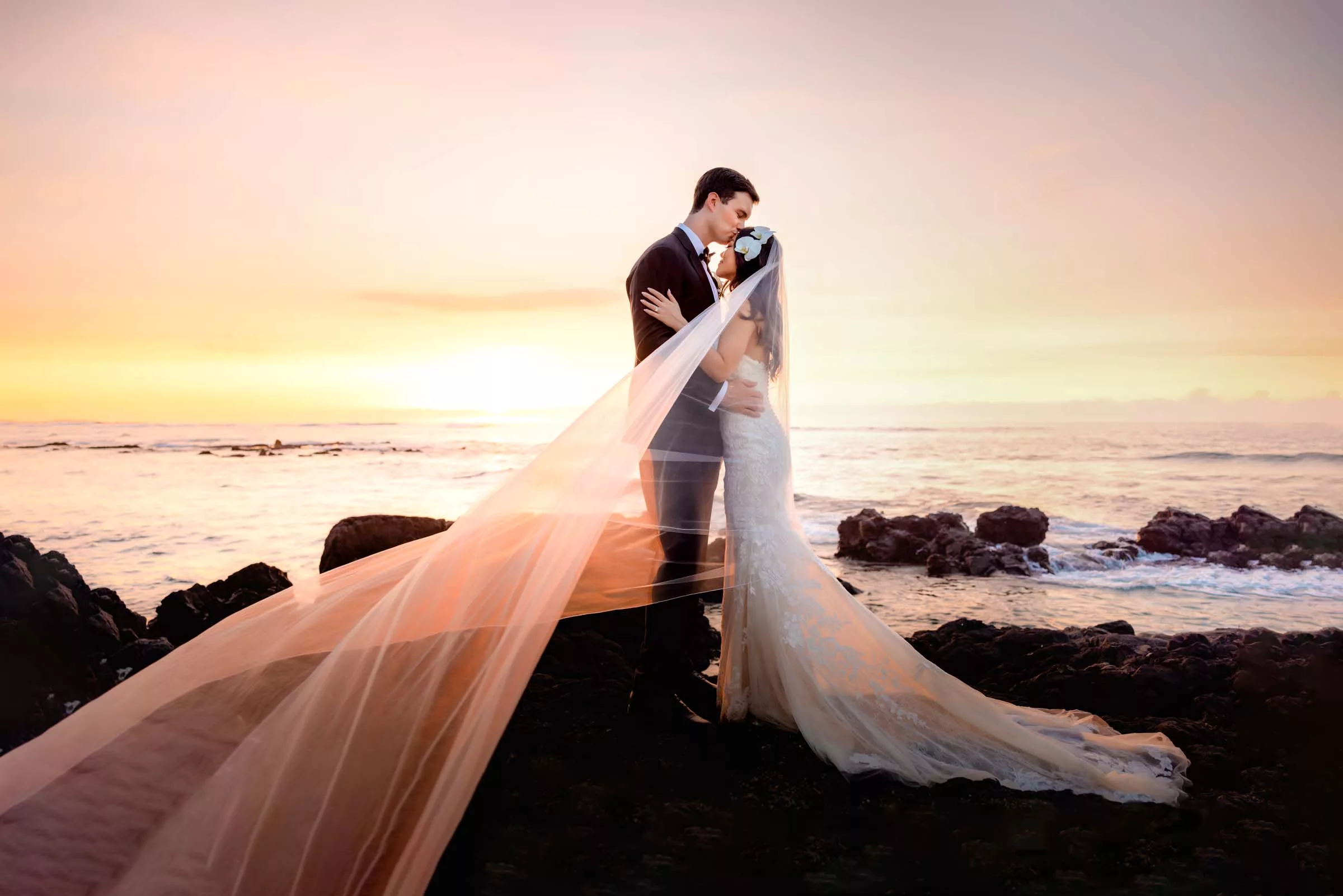Couple on lava during the sunset after their big island wedding